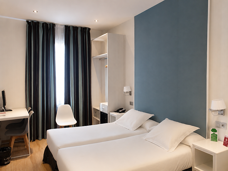 Moderna camera doppia presso l'Hotel Bellavista con letti bianchi, armadio e scrivania.