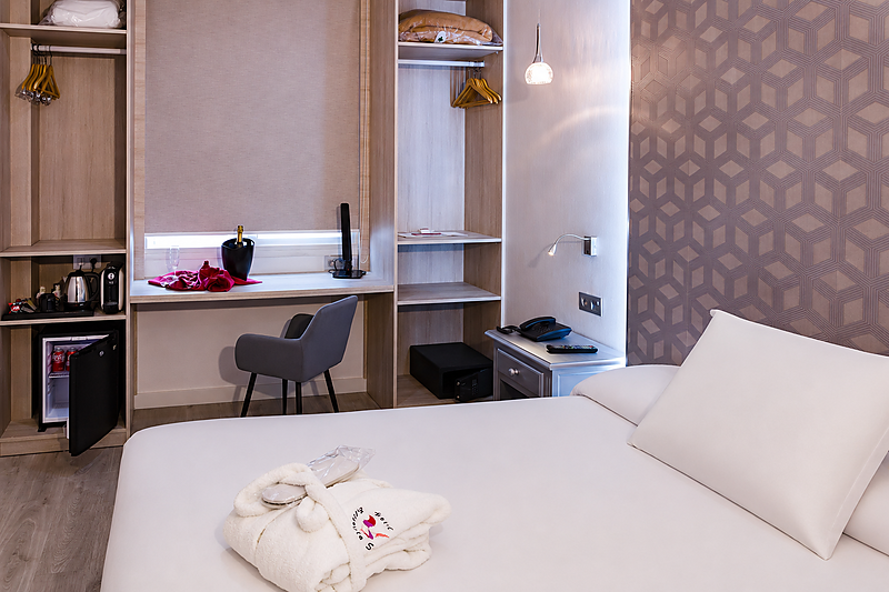 Camera Hotel Bellavista accogliente con letto, scrivania e minifrigo.
