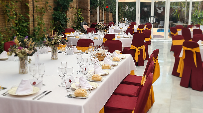 Hotel Bellavista event room: long tables, red and gold chairs.