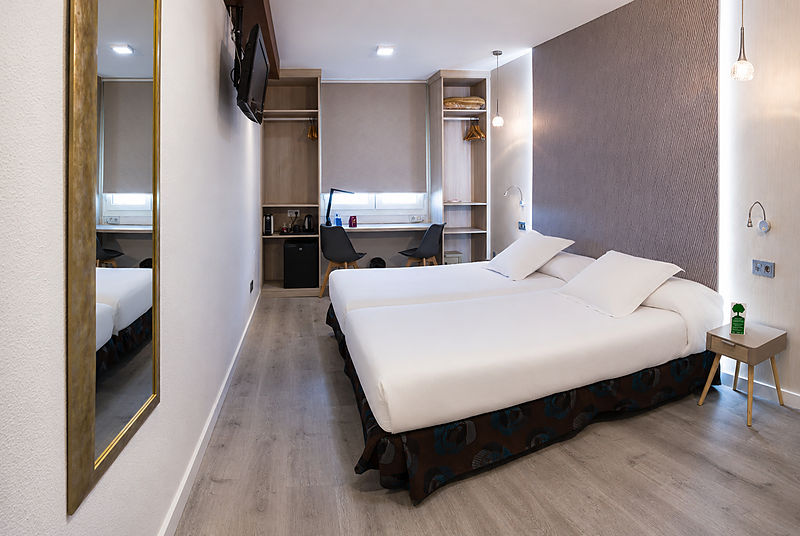 Camera doppia all'Hotel Bellavista con letti bianchi, armadio e scrivania.