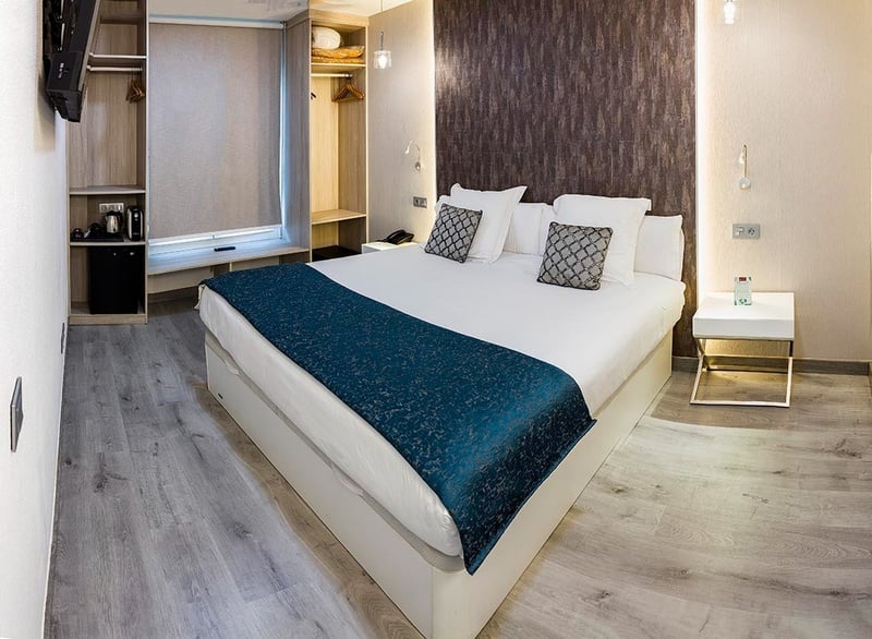 a hotel room with a bed and a small fridge