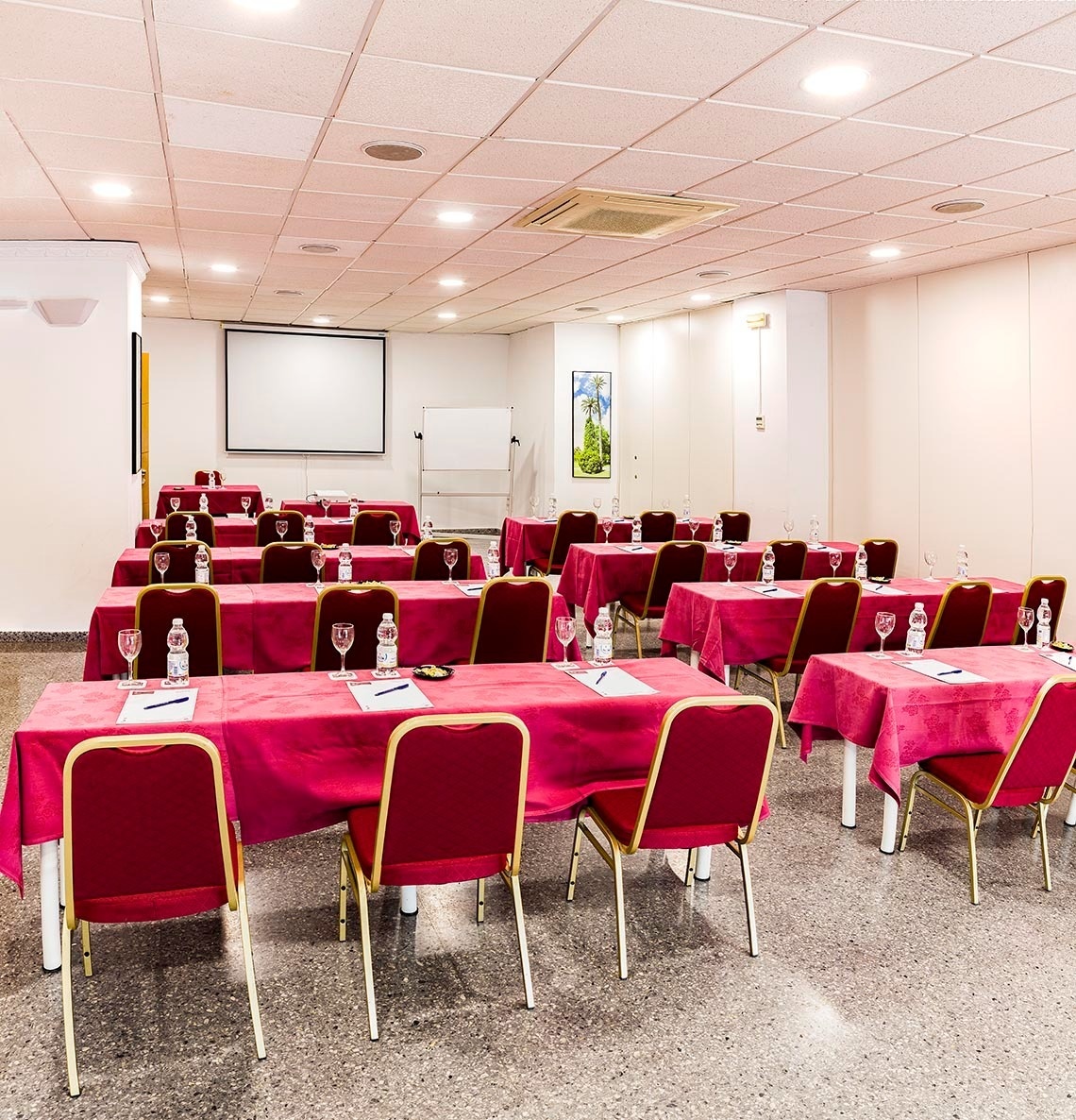 une salle de conférence avec des tables et des chaises rouges