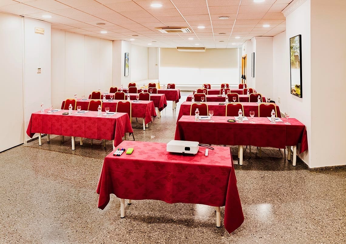 une salle de conférence avec des tables et des chaises et un projecteur