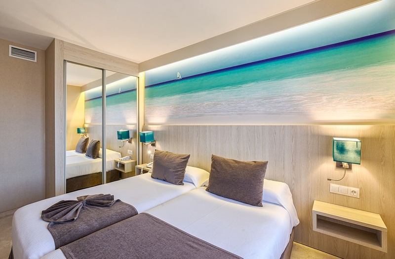 a hotel room with a picture of the ocean on the wall