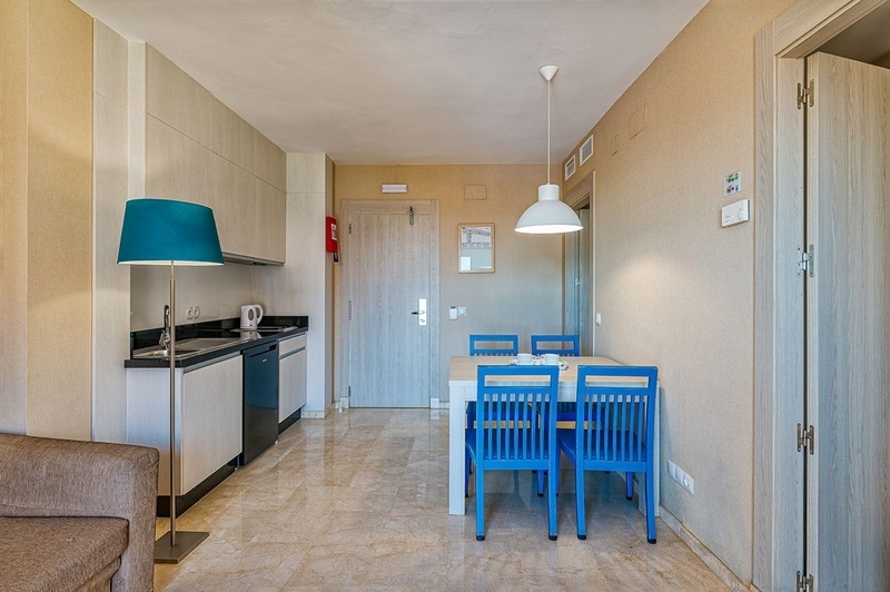 een woonkamer met een eettafel en blauwe stoelen