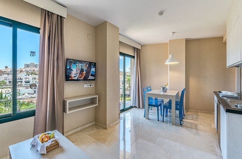 a hotel room with a table and chairs and a flat screen tv