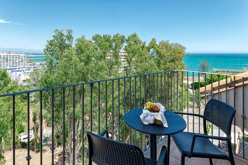 a balcony with a table and chairs overlooking the ocean