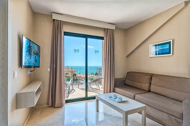 een woonkamer met een bank en een flatscreen tv