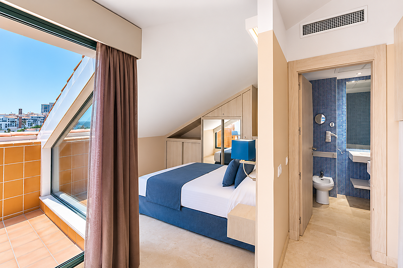 Kamer met balkon, bed en badkamer met blauw mozaïek in het Benalmádena Palace