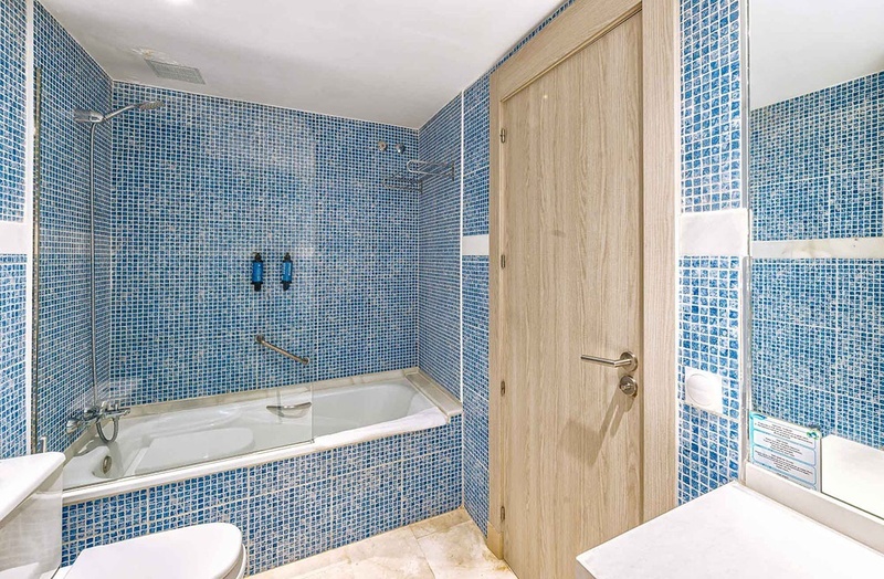 een badkamer met blauwe tegels en een bad