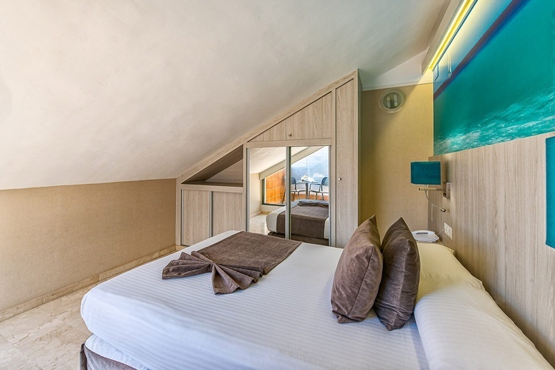 een hotelkamer met een bed en een spiegel