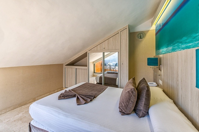 a hotel room with a bed and a large mirror