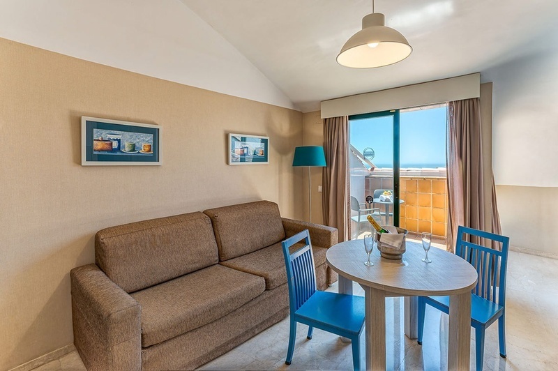 een woonkamer met een tafel en stoelen en een bank