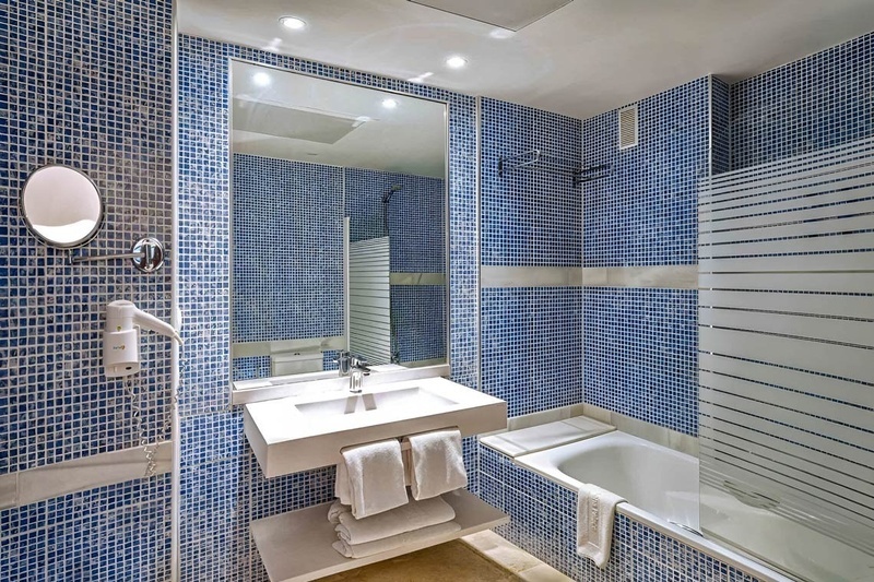 un baño con azulejos azules y blancos y una bañera