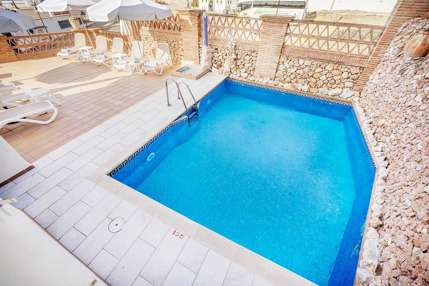 una piscina con palmeras y edificios en el fondo