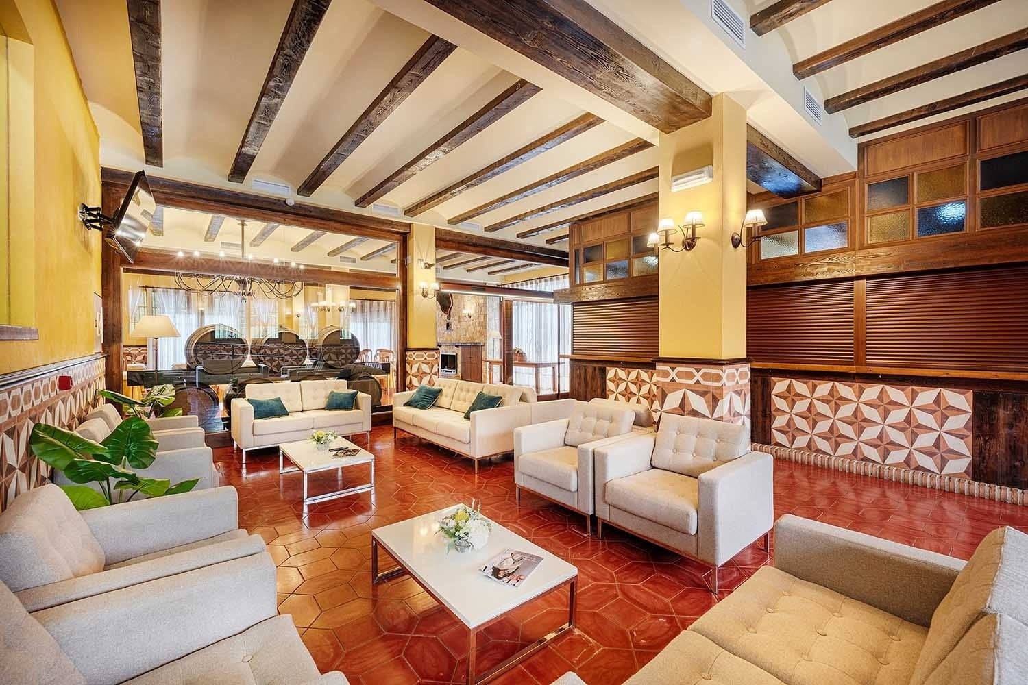 Sala de estar con sofás, mesas bajas y decoración rústica. Cazorla Hotel | Beneste Hoteles | Web oficial.