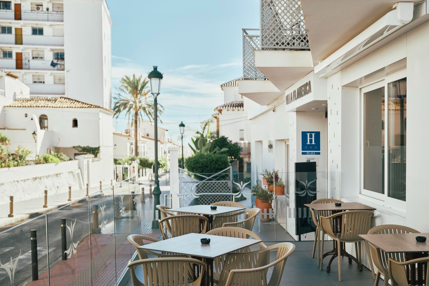 Terraza del Snack Bar Villa Flamenca: mesas exteriores y sillas acogedoras. ¡Reserva ya en Beneste Hoteles!
