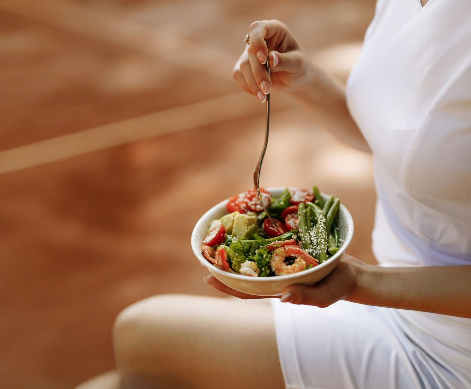 un adorno rojo colgando de una rama de un árbol de navidad cubierto de nieve