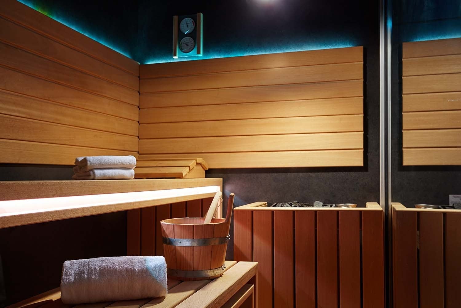Sauna de madera con toallas y lámpara, Servicios | Villa Flamenca | Beneste Hoteles | Web oficial