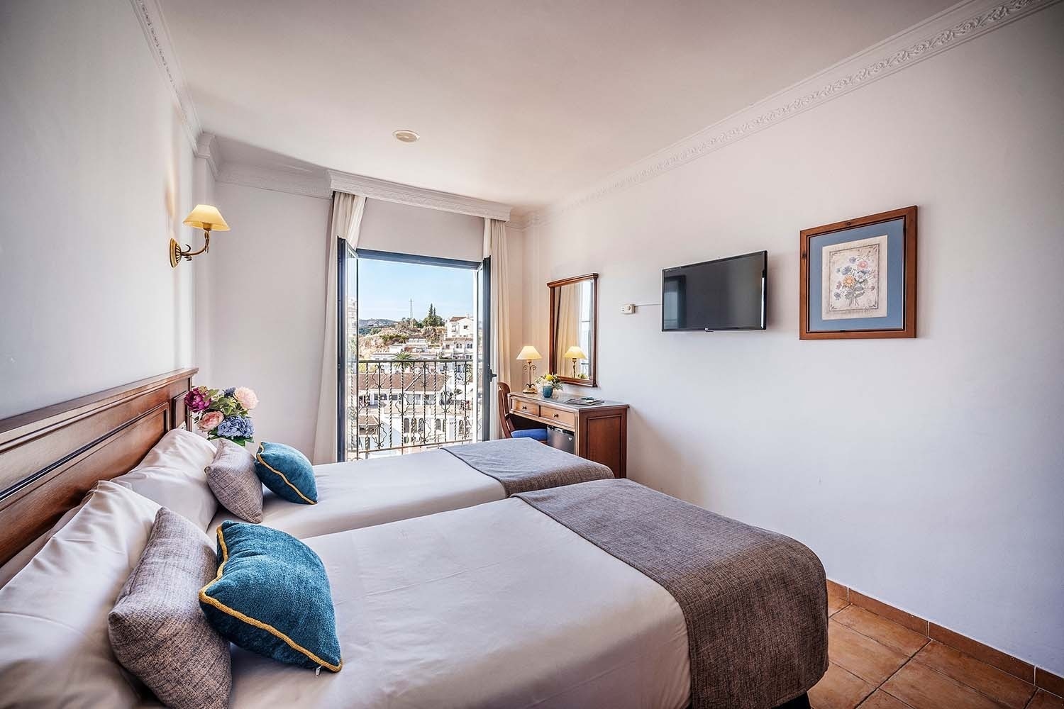 Modern hotel rooms with twin beds and a balcony view | Frigiliana Hotel | Beneste Hotels | Official Website