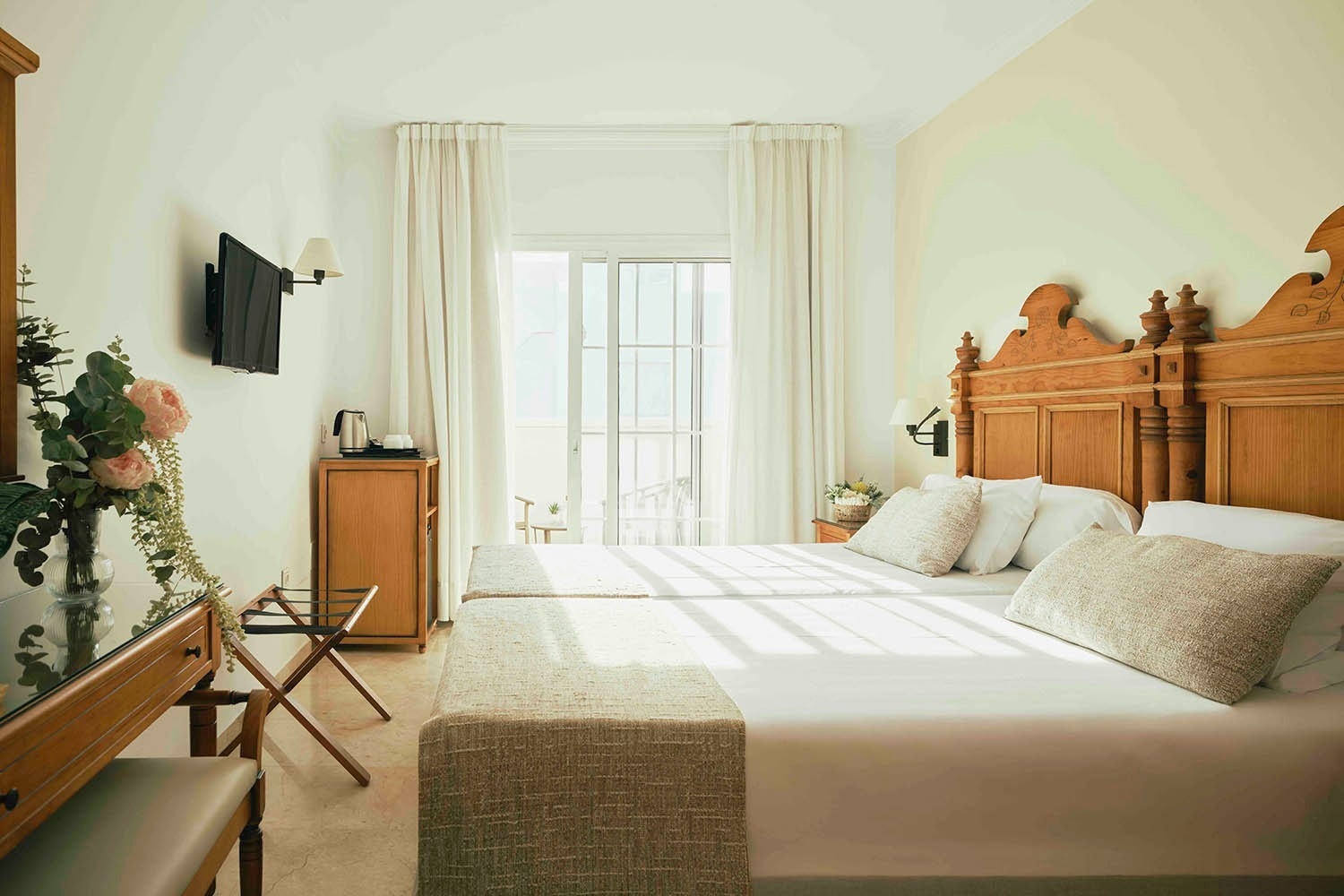 una habitación de hotel con dos camas y una televisión