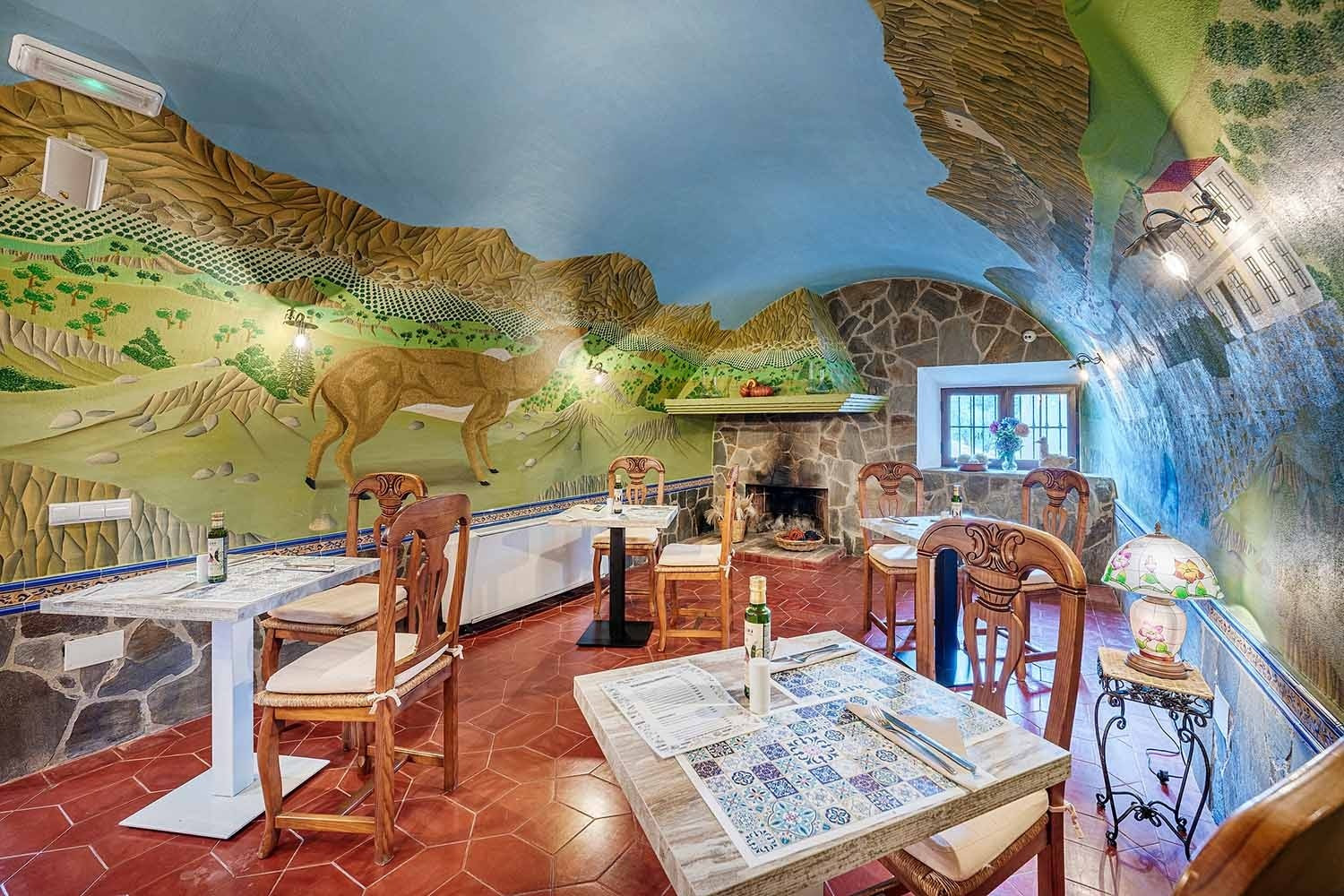Restaurante con murales de paisaje y ciervo. Gastronomía en Hotel Cazorla | Beneste Hoteles | Web oficial