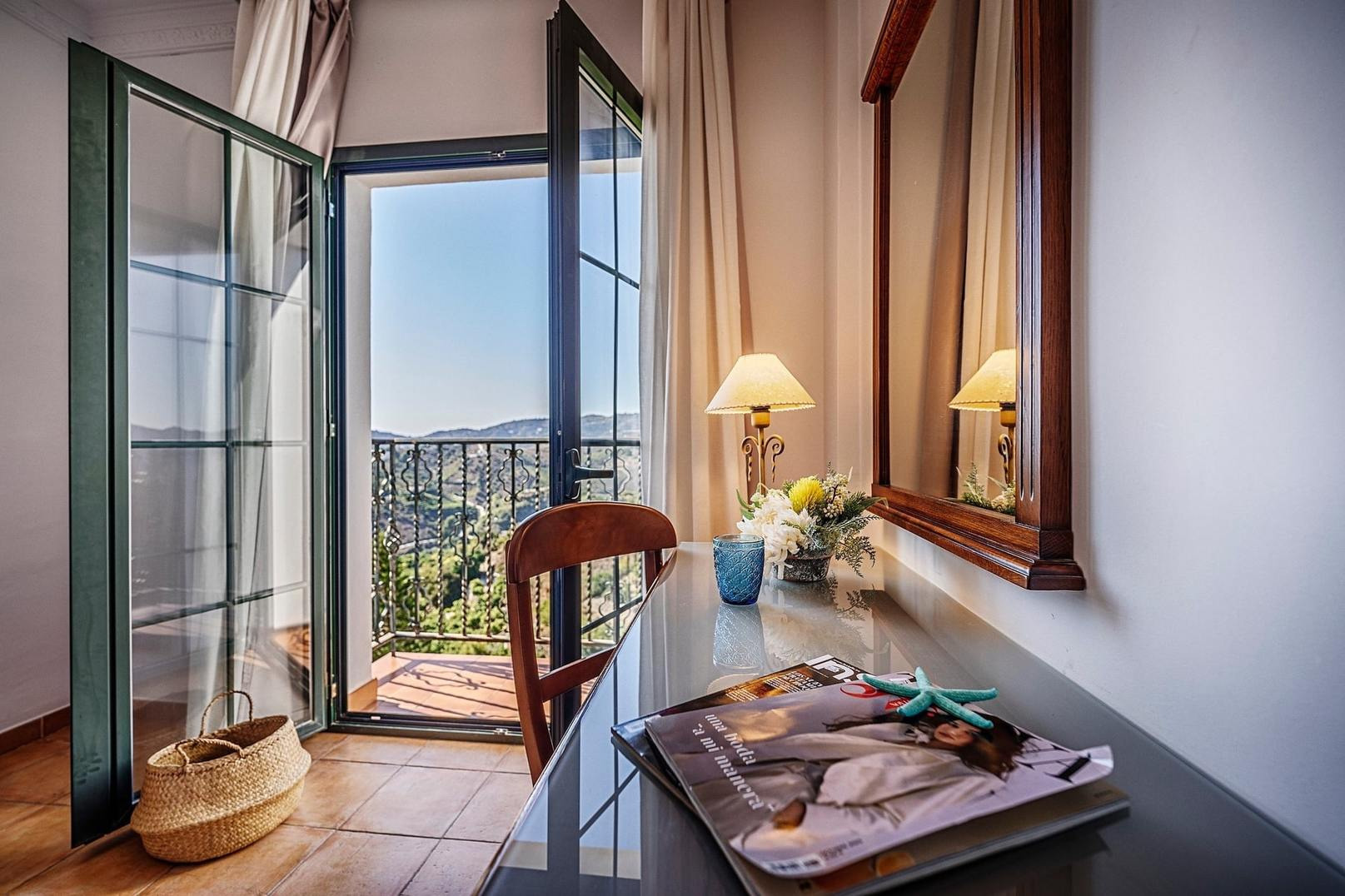 Habitaciones: Escritorio con vista al balcón, espejo y revista. Hotel Frigiliana, Beneste Hoteles, Web oficial.