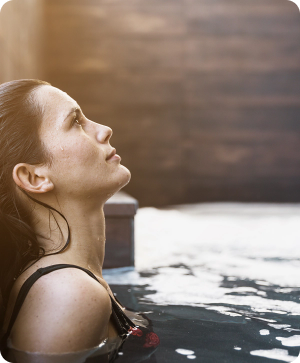 una mujer se sienta en una piscina mirando hacia arriba
