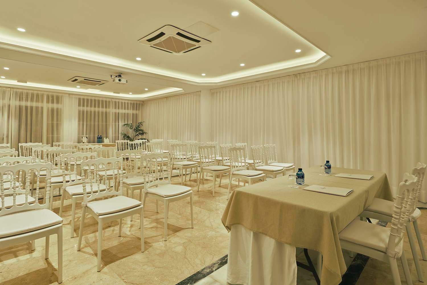 Sala de conferencias blanca lista para eventos en Villa Flamenca, Beneste Hoteles.