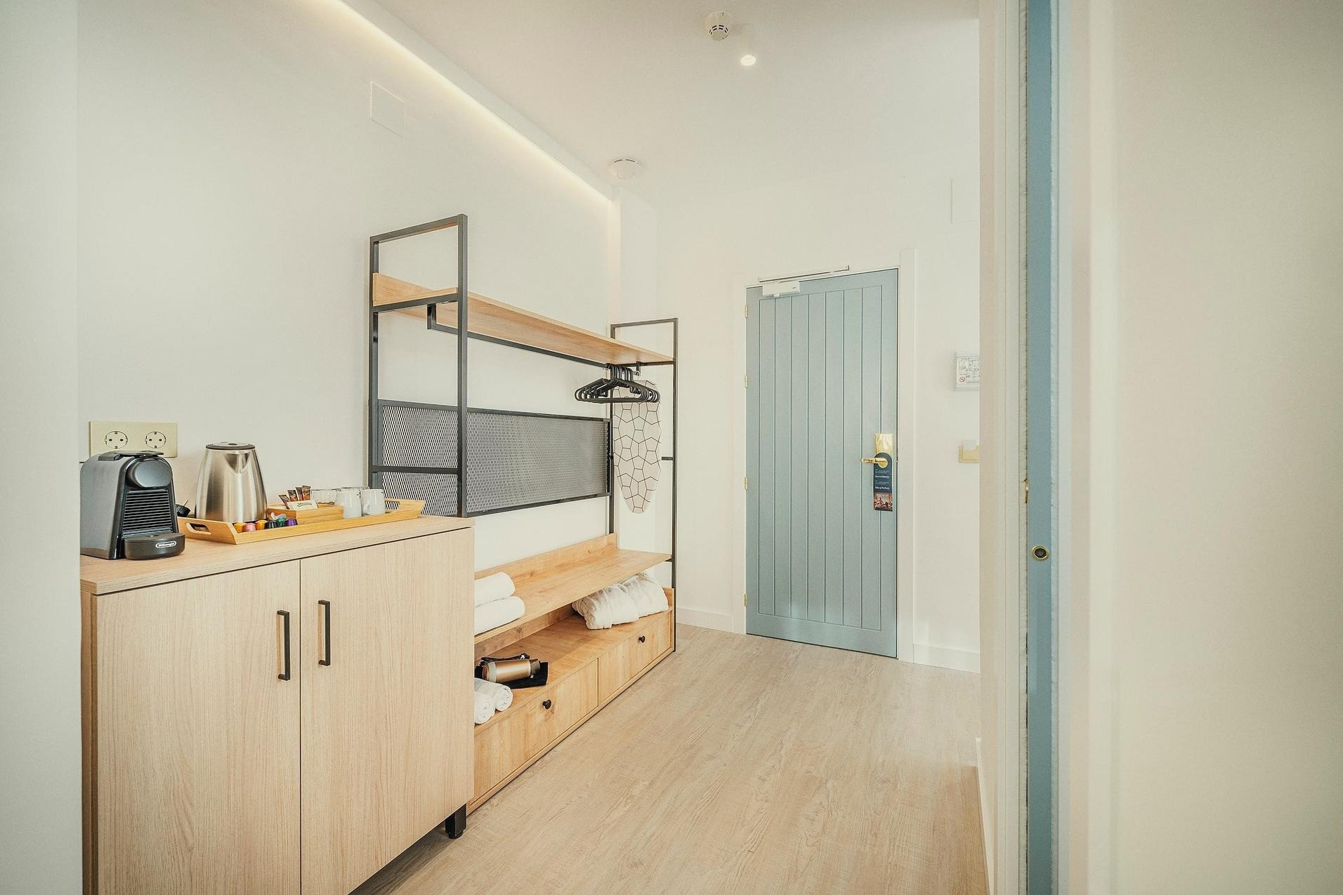 Habitación moderna BENESTE: Corporativa con cafetera, hervidor y puerta de madera clara.