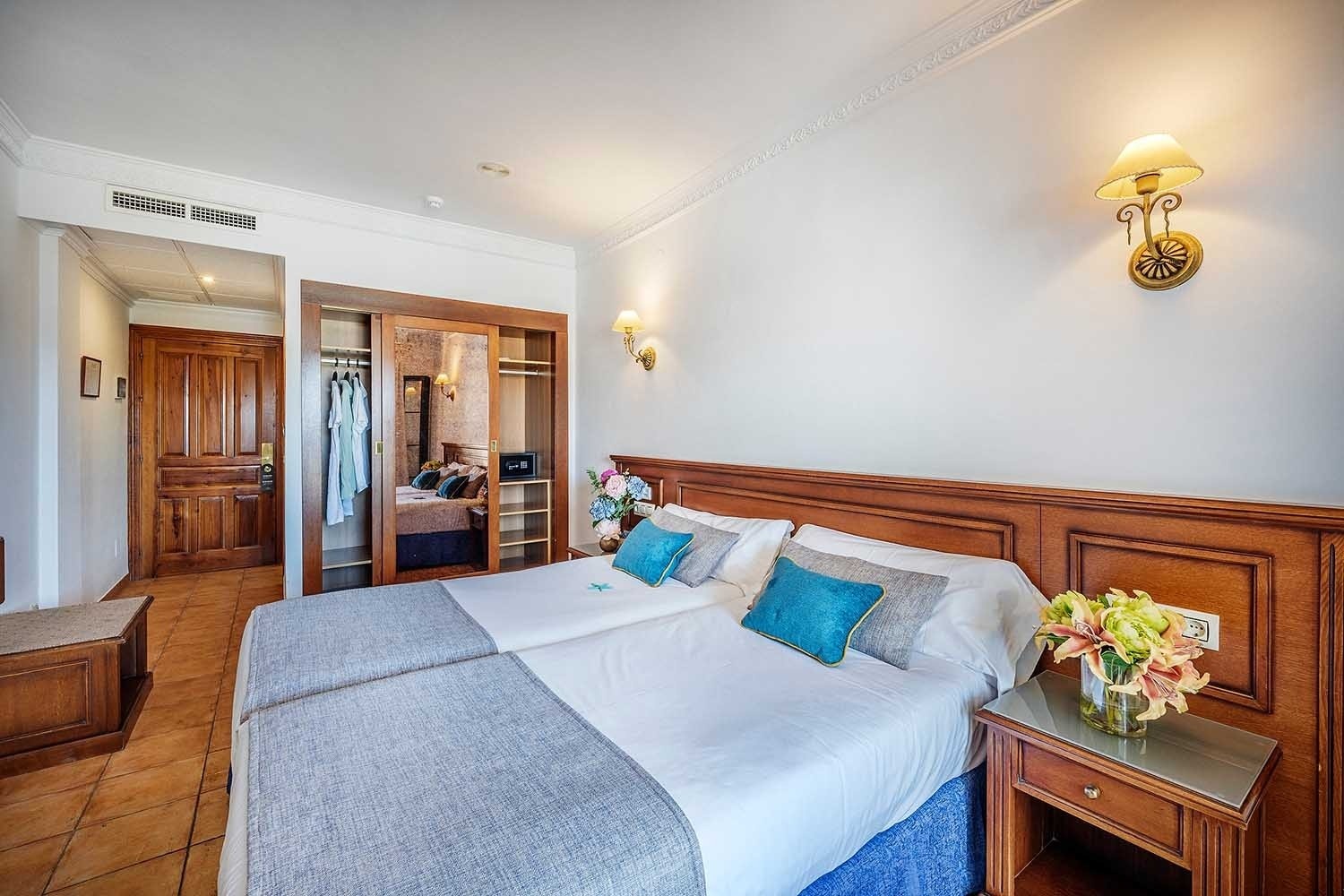 Habitación doble con armario empotrado y puerta de madera en Frigiliana Hotel | Beneste Hoteles | Web oficial
