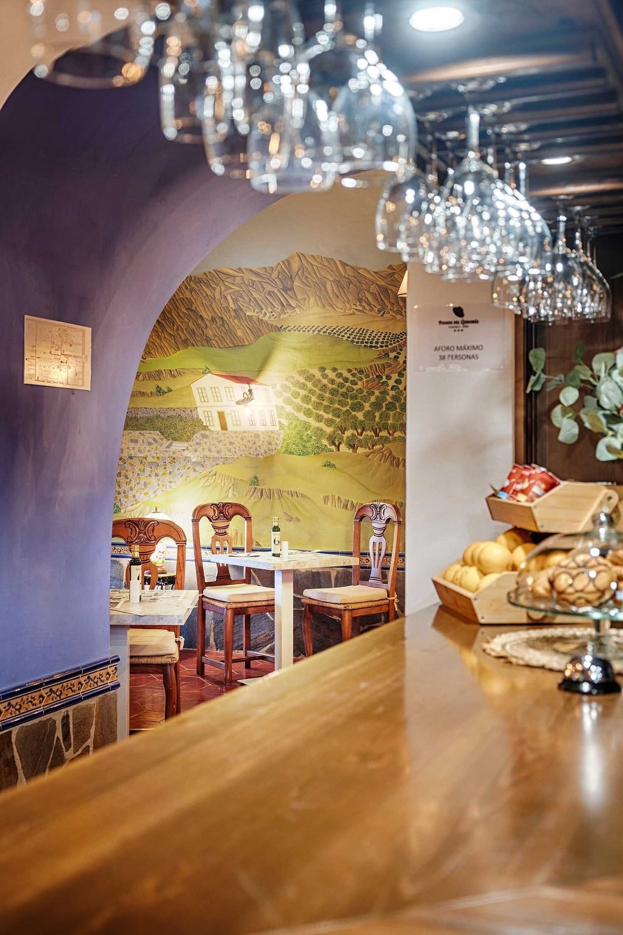 Acogedor salón con mural paisajístico, mesas y sillas de madera en Cazorla Hotel | Beneste Hoteles | Web oficial.