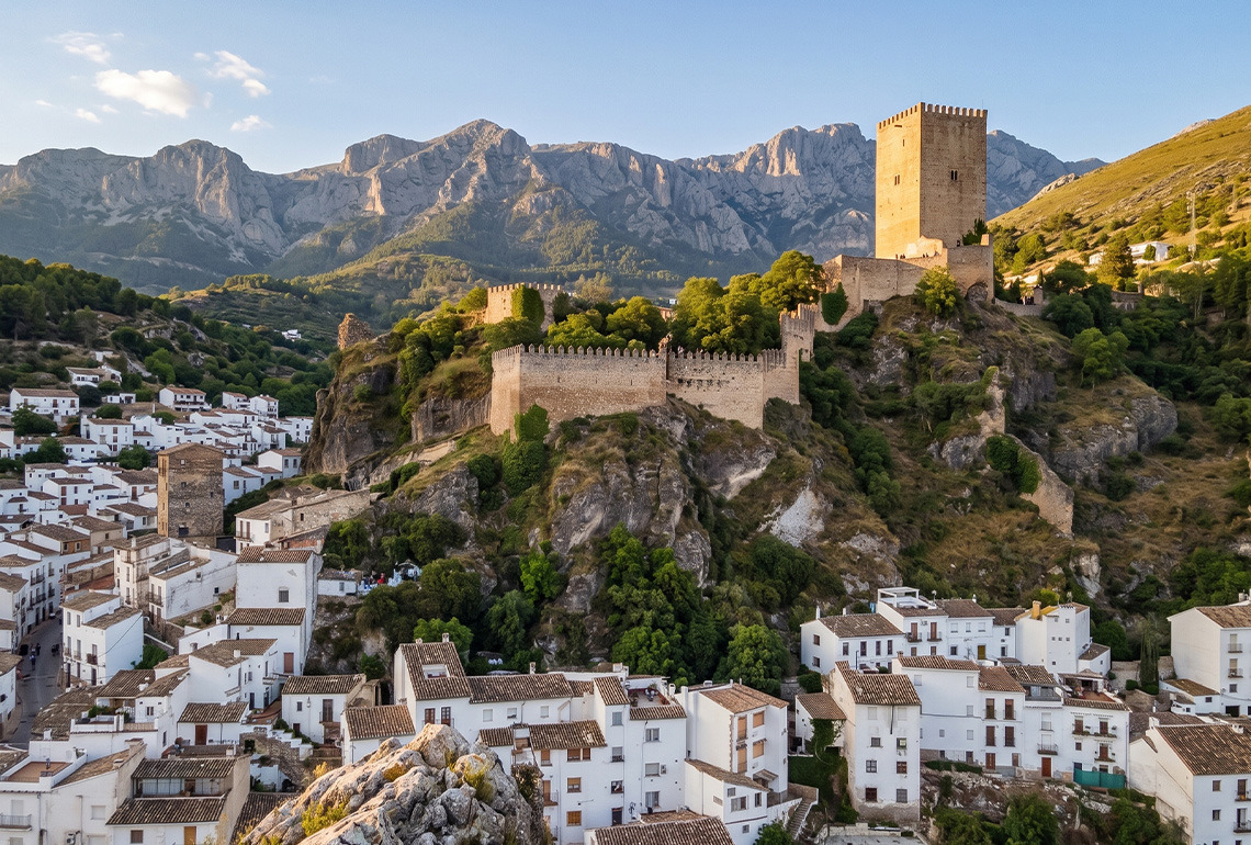 Pueblo blanco con castillo en la montaña, ideal para BENESTE: Corporativa y turismo rural.