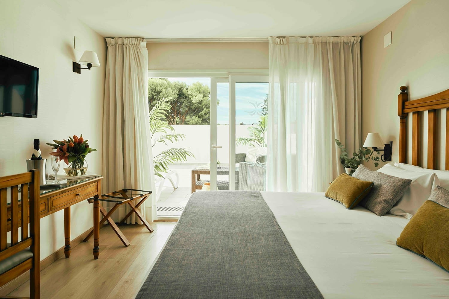 una habitación de hotel con dos camas y una televisión en la pared