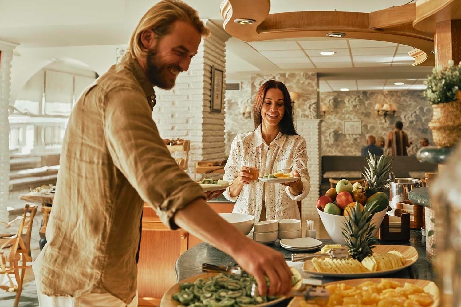 Pareja disfrutando de un buffet de desayuno en Villa Flamenca | Beneste Hoteles