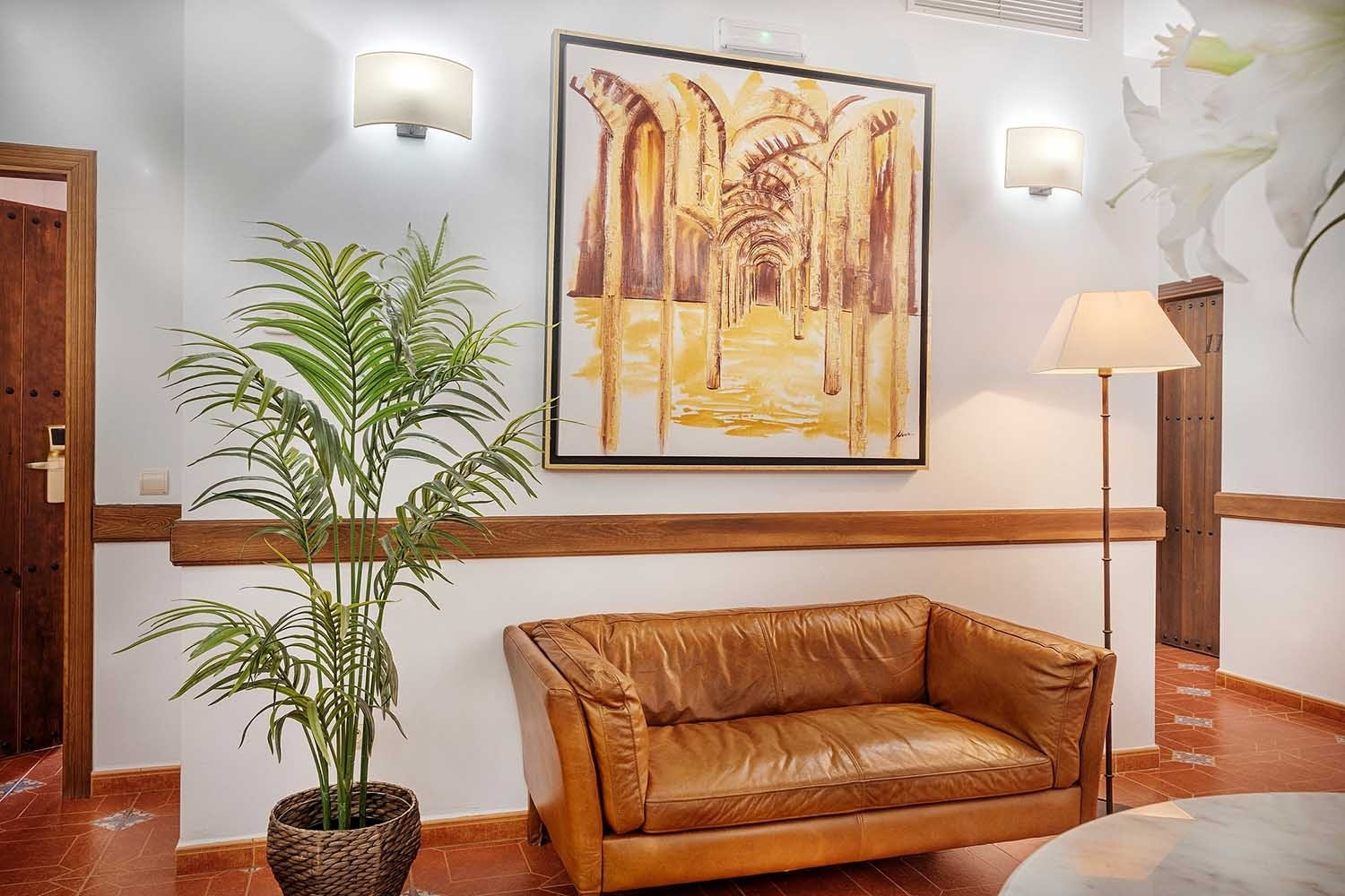 Stylish lobby with leather sofa, plant, art & lamp. Book Services | Cazorla Hotel | Beneste Hotels | Official Website