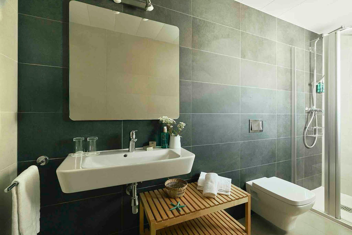 Modern bathroom with sink, shower, and toilet in Rooms | Villa Flamenca | Beneste Hotels.