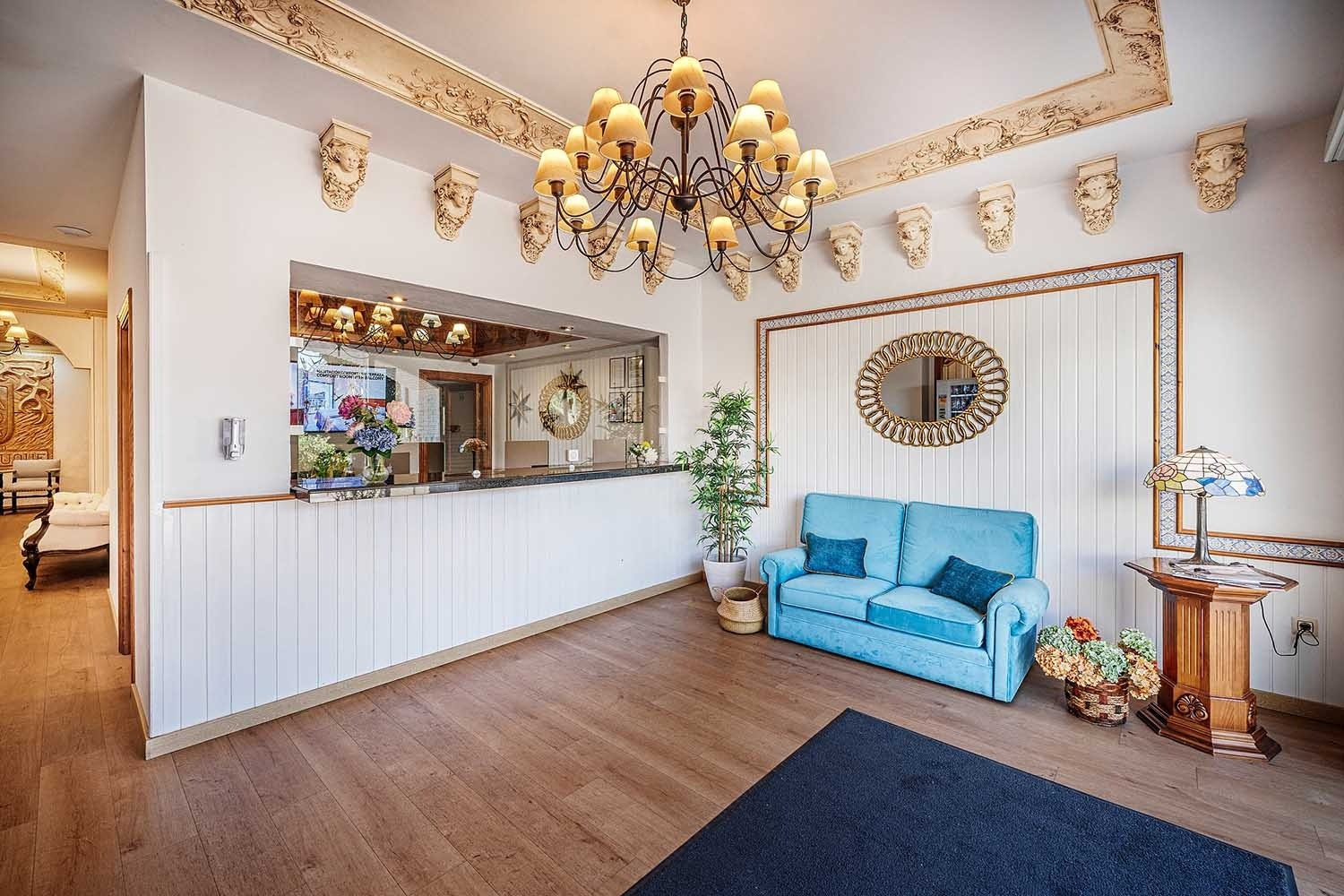 Elegant hotel lobby with blue sofa & reception desk. Services | Frigiliana Hotel | Beneste Hotels | Official Website.