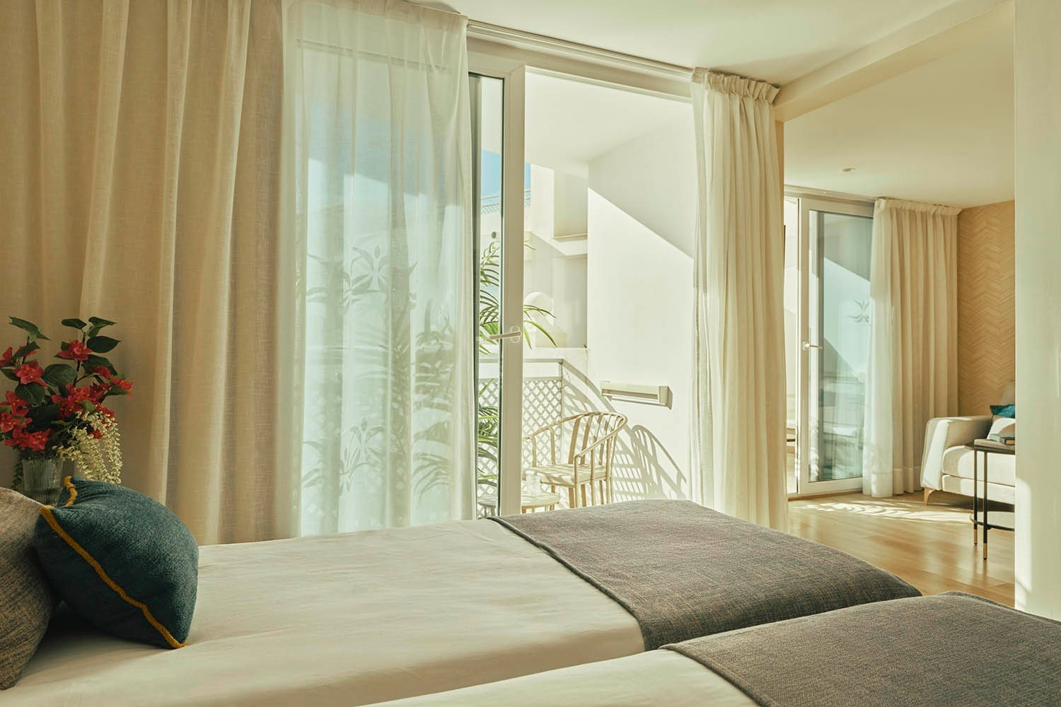 Twin beds in a bright, modern hotel room with balcony access. Rooms | Villa Flamenca | Beneste Hotels | Official Website.