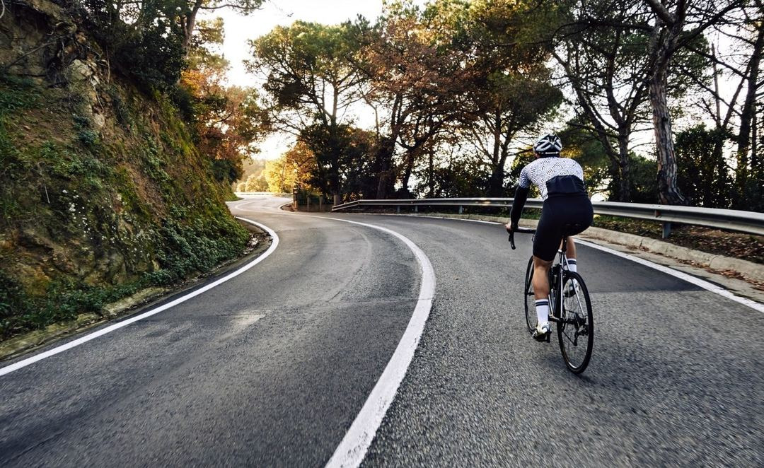 Cyclist on scenic road BENESTE: Corporativa, perfect for active getaways.