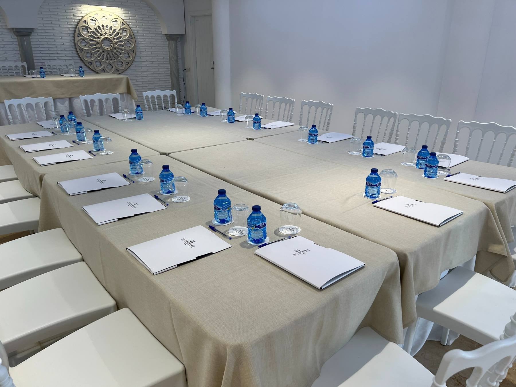 Sala de reuniones BENESTE: Corporativa lista con sillas, botellas de agua y material.