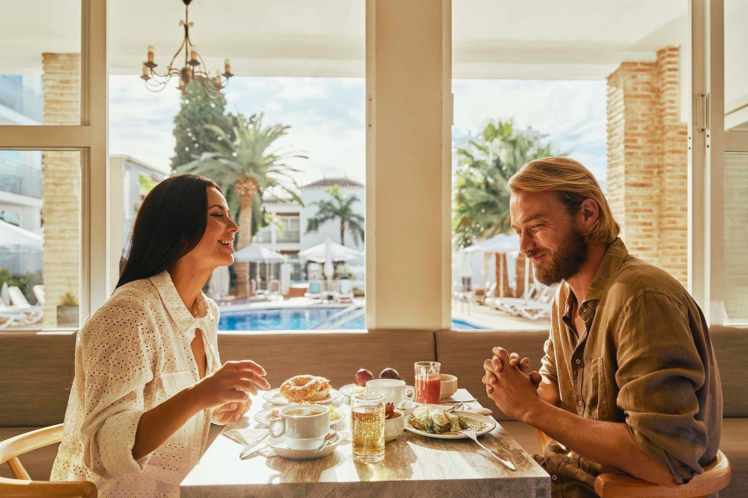 Pareja disfrutando un desayuno junto a la piscina. Villa Flamenca | Beneste Hoteles.
