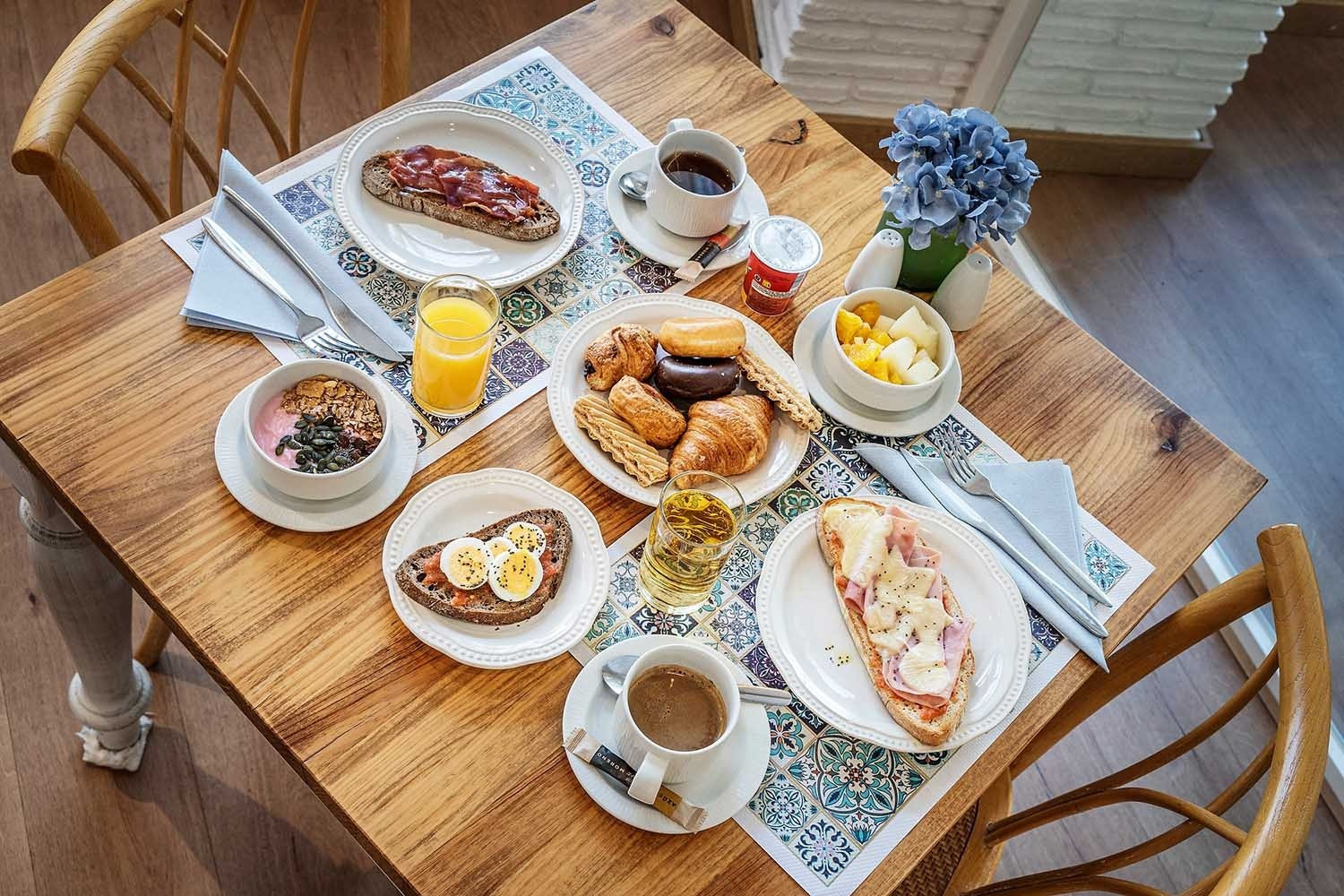 Hotel breakfast spread: eggs, pastries, fruit, coffee. Services | Frigiliana Hotel | Beneste Hotels | Official Website
