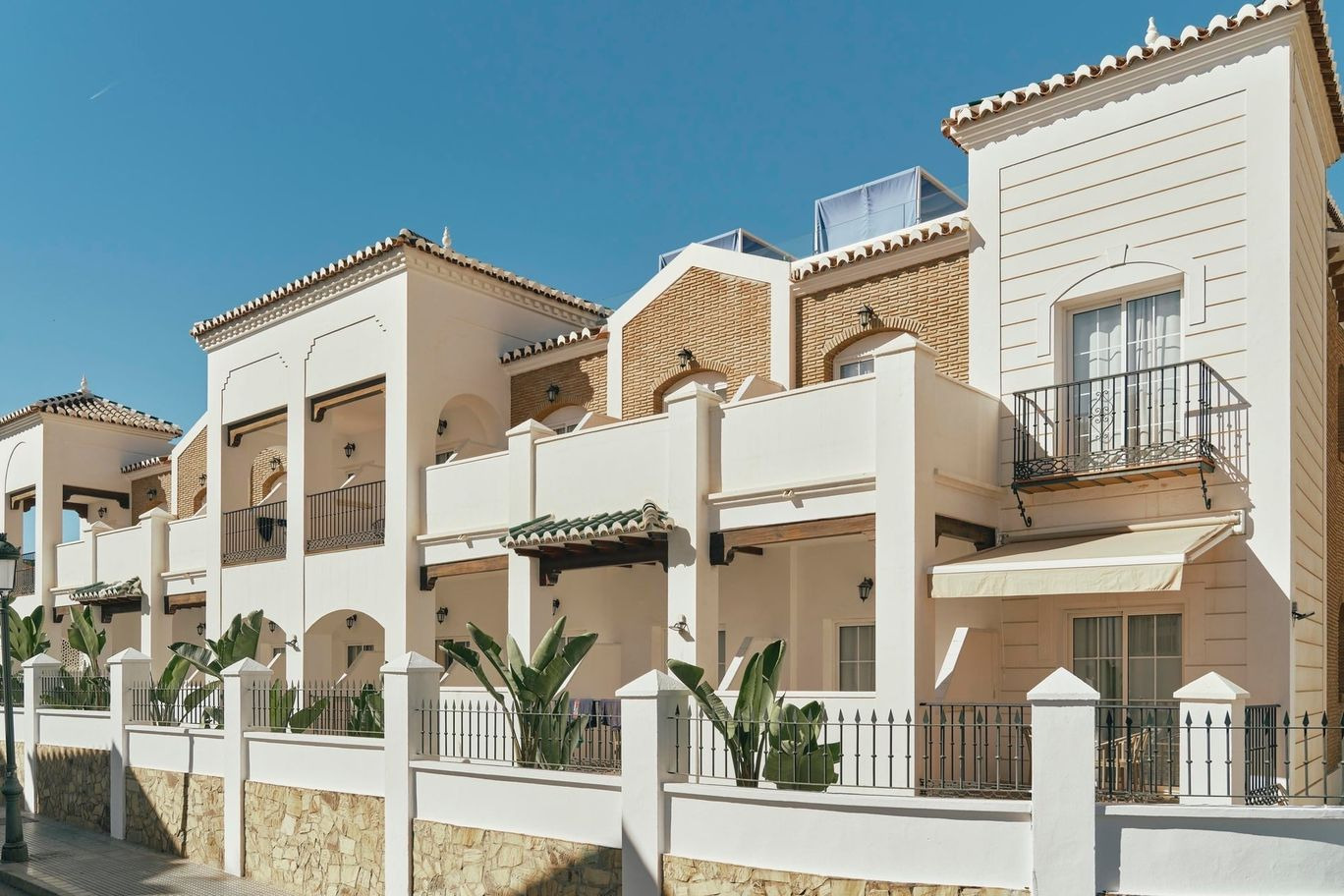 BENESTE: Corporativa. Modern hotel facade with balconies and tropical plants.