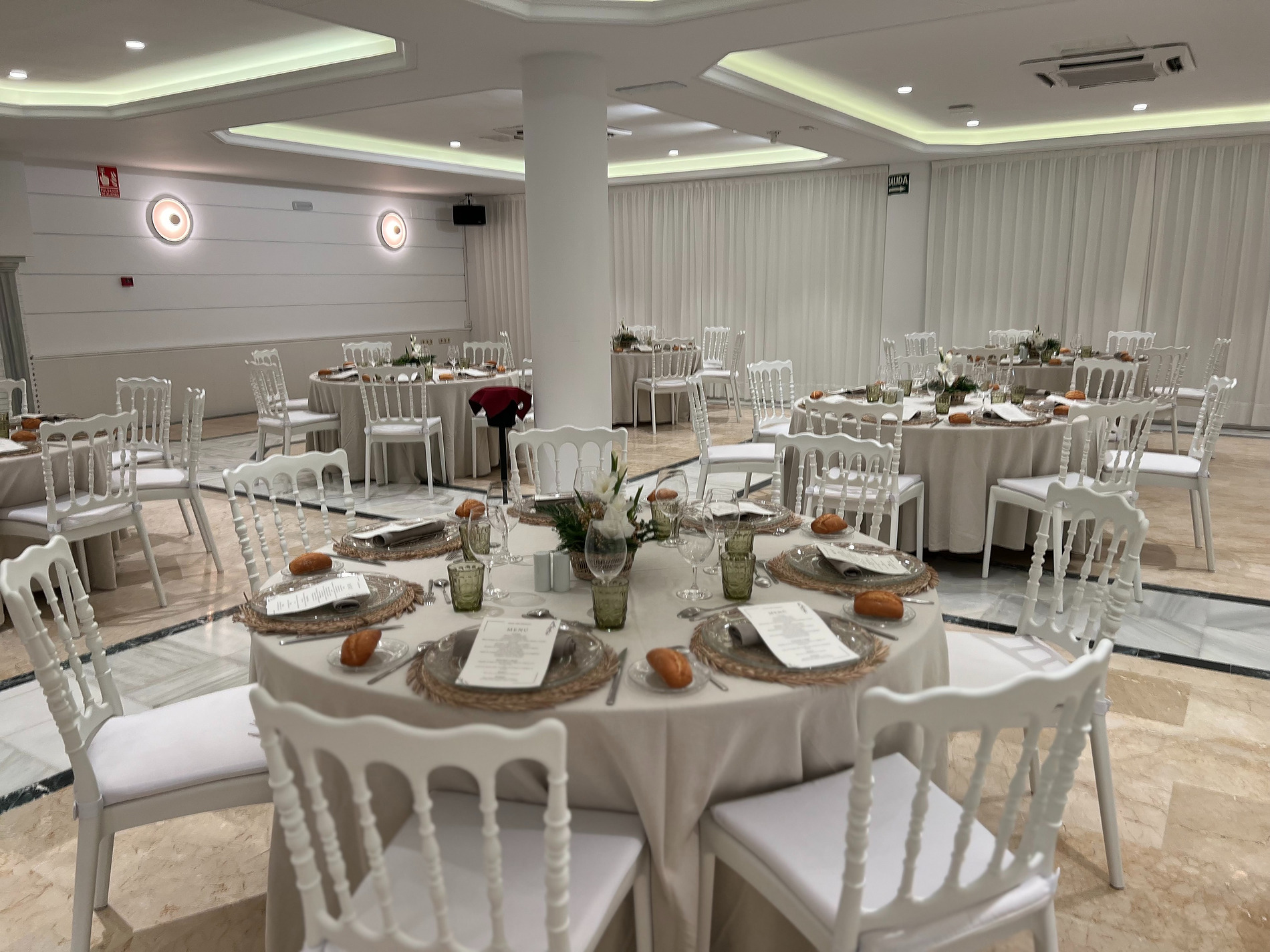 Salón de banquetes elegante con mesas redondas puestas para eventos en Villa Flamenca.