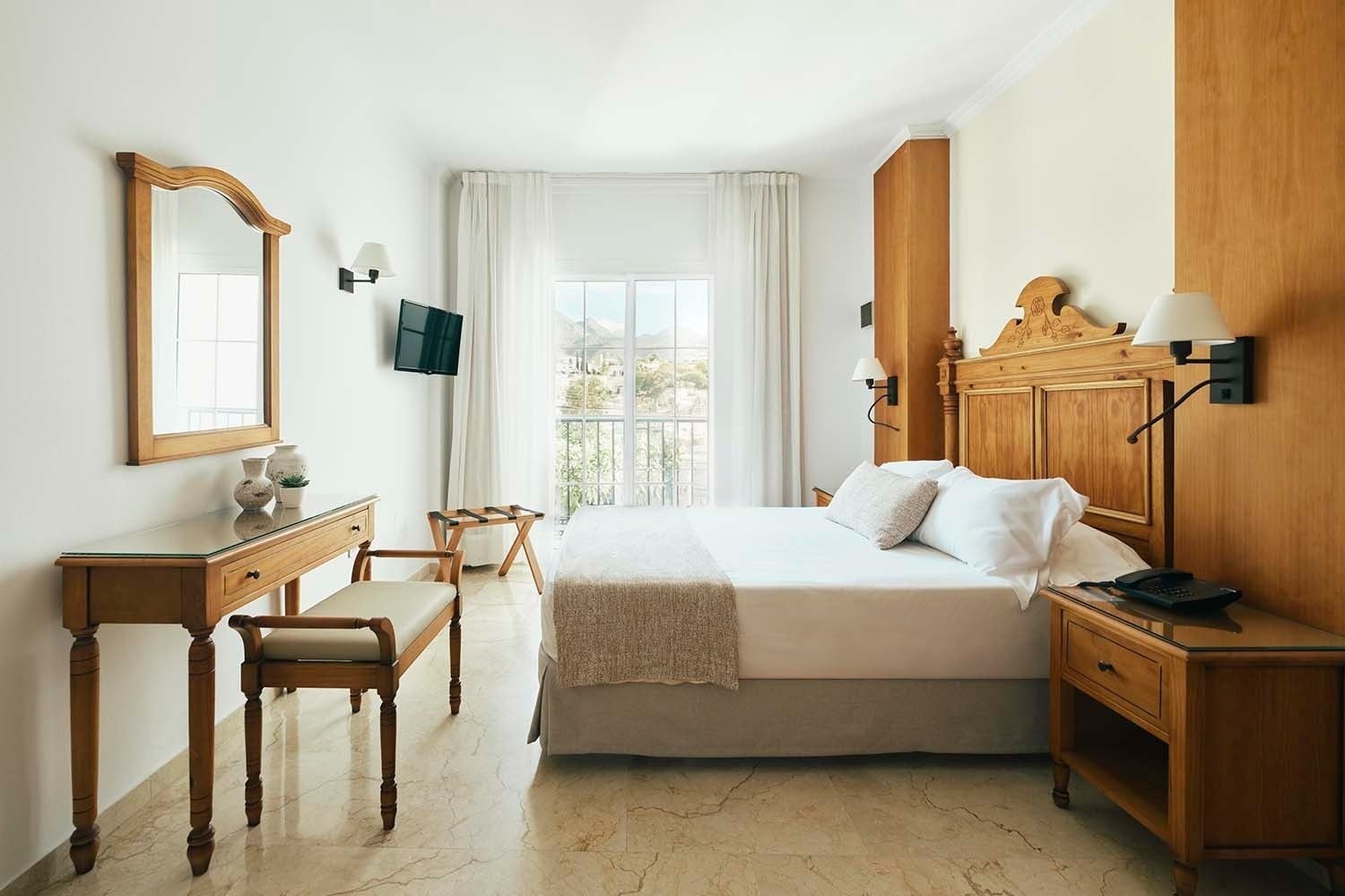Habitación acogedora en Villa Flamenca | Beneste Hoteles, con cama doble, tocador y vistas.
