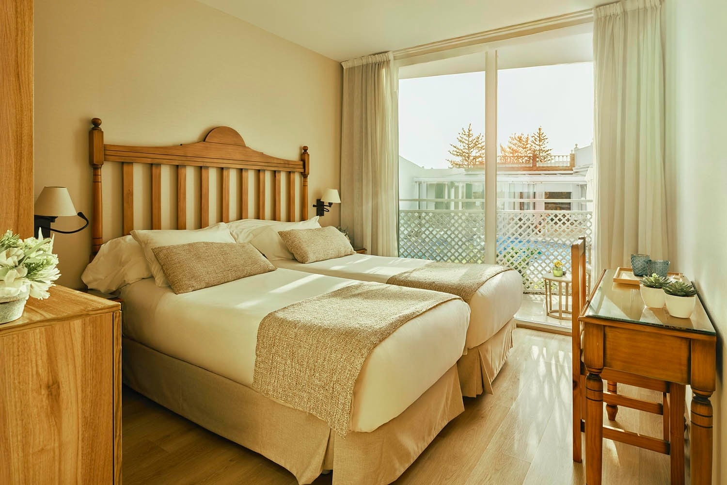 una habitación con dos camas y una ventana con vista a una piscina