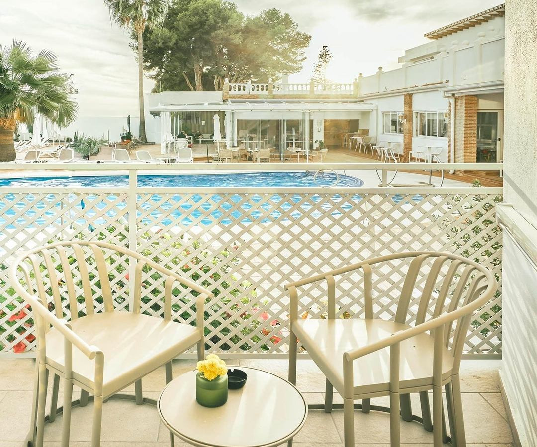 Balcony seating with pool view. Rooms | Villa Flamenca | Beneste Hotels | Official Website.