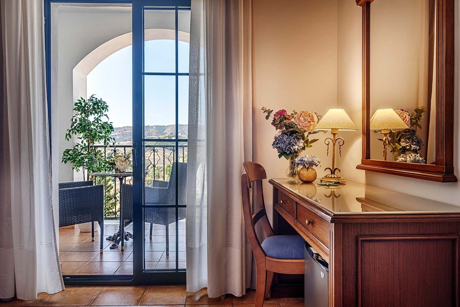 una mesa y dos sillas en un balcón con una vista de las montañas