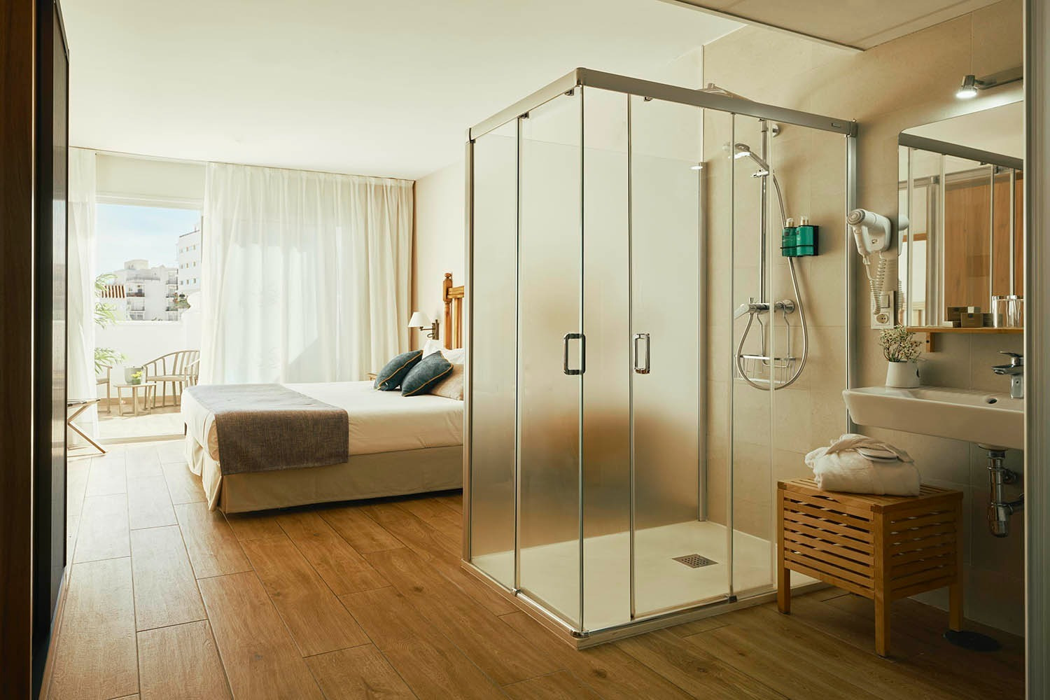 Modern hotel room with king bed, glass shower, and balcony view. Rooms | Villa Flamenca | Beneste Hotels | Official Website.